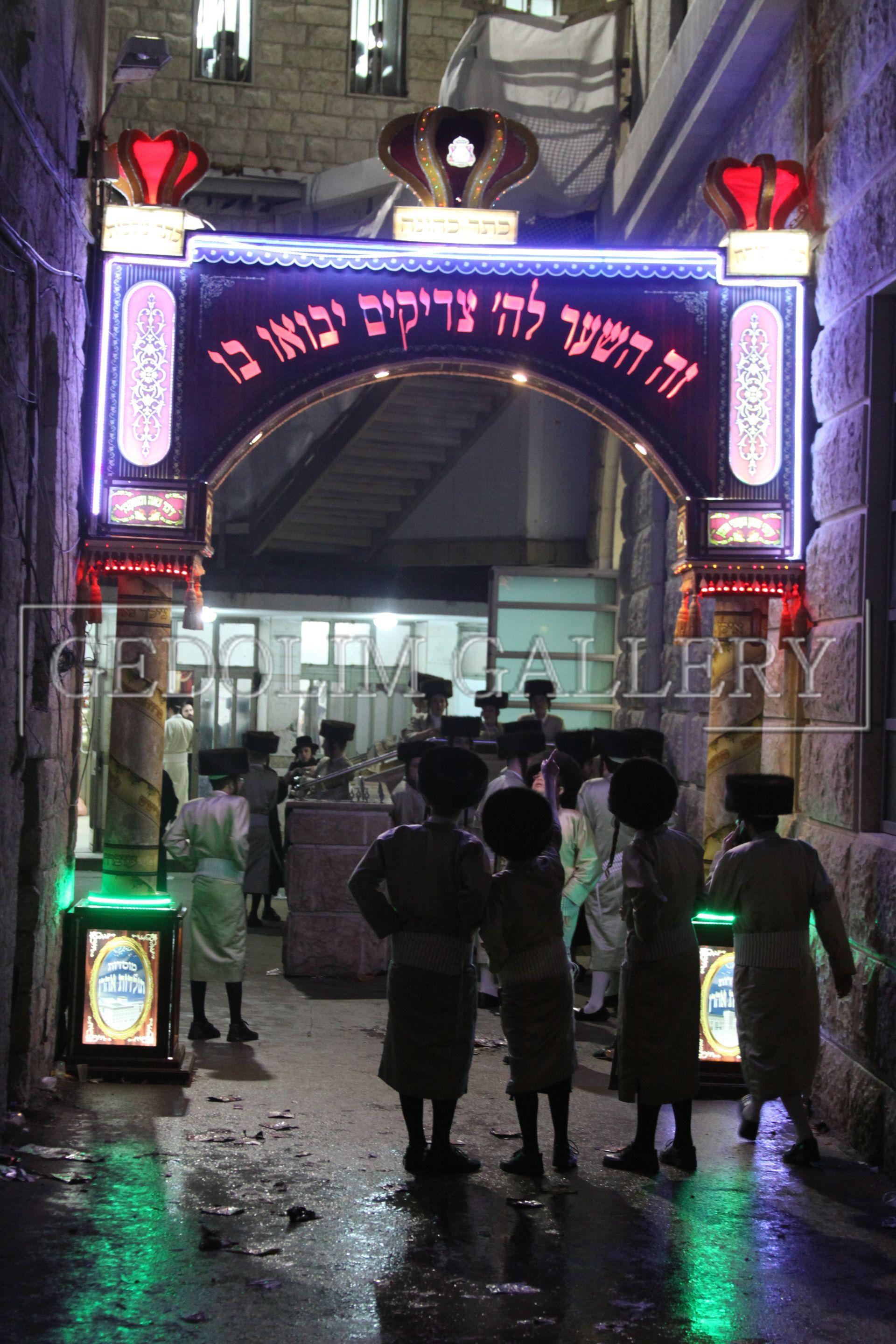 A group of people standing under a sign that says ' hebrew ' on it