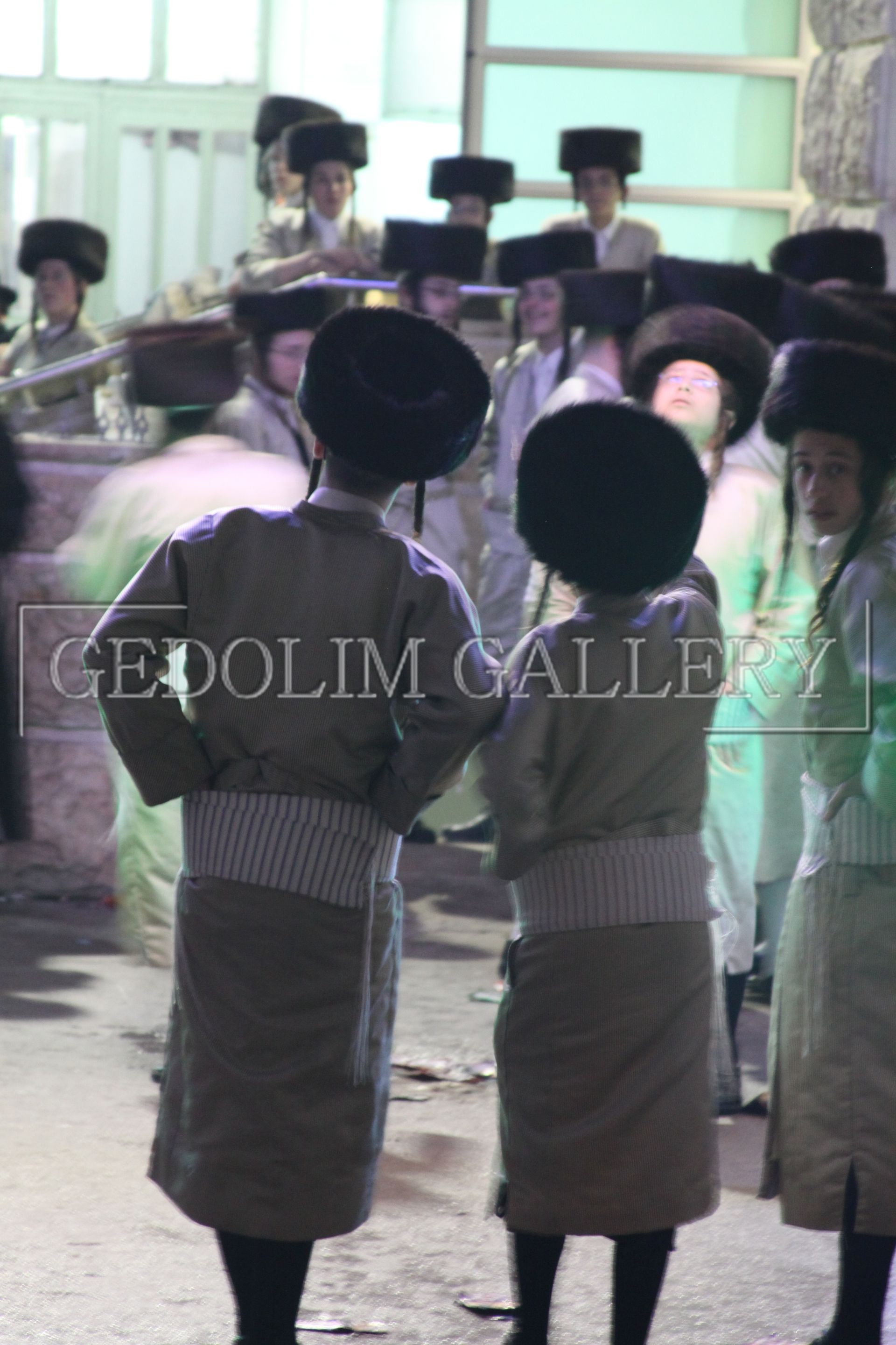 A group of people standing in front of a gedolim gallery sign