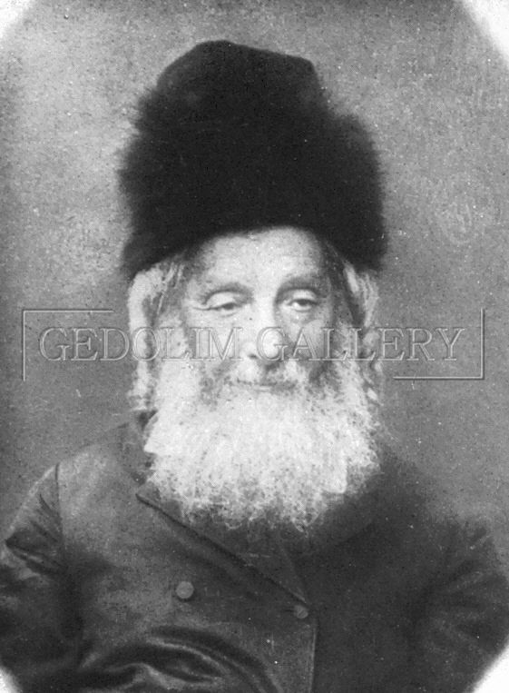 A black and white photo of a man with a beard wearing a fur hat.