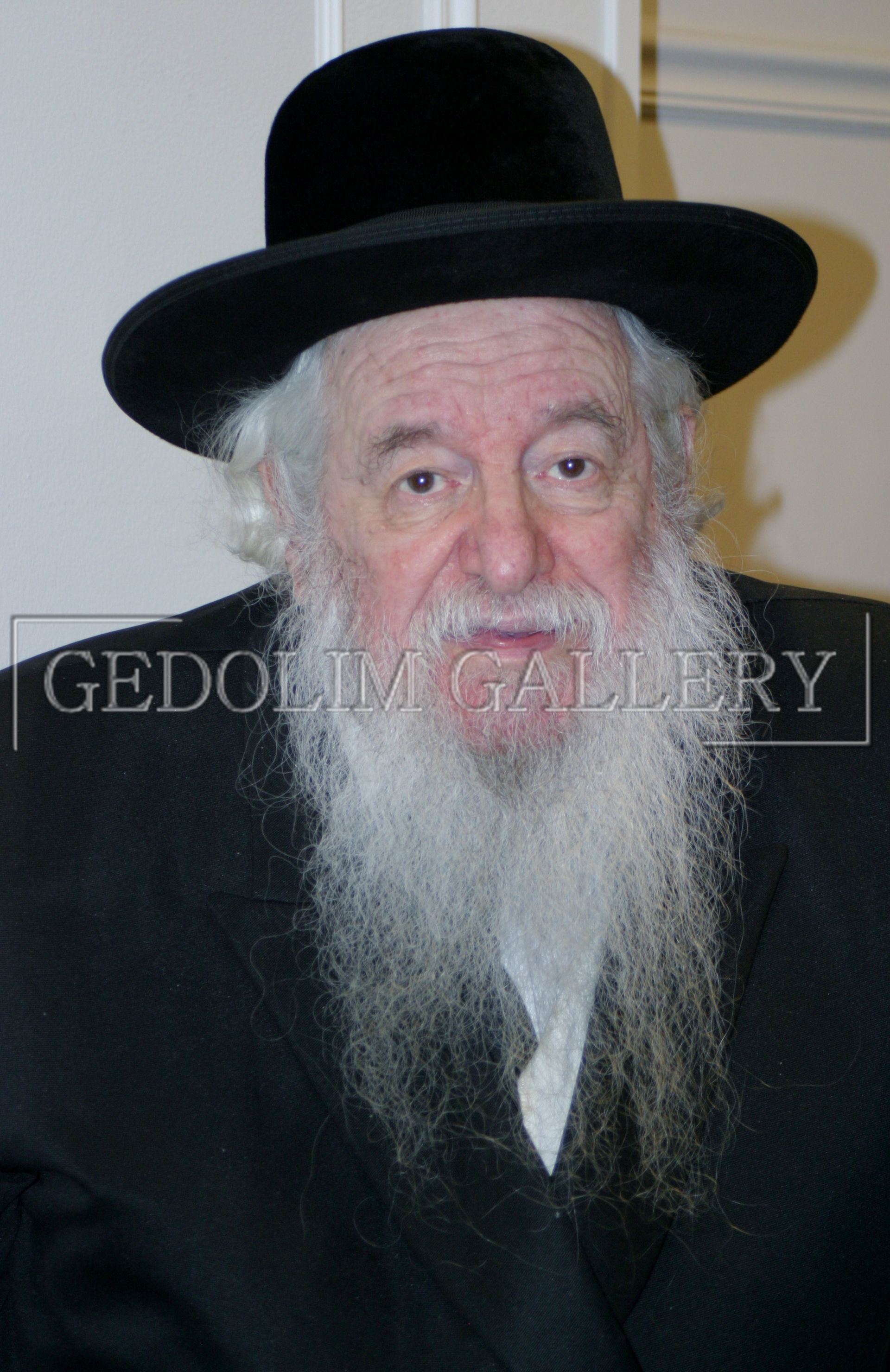 A man with a beard is wearing a black hat