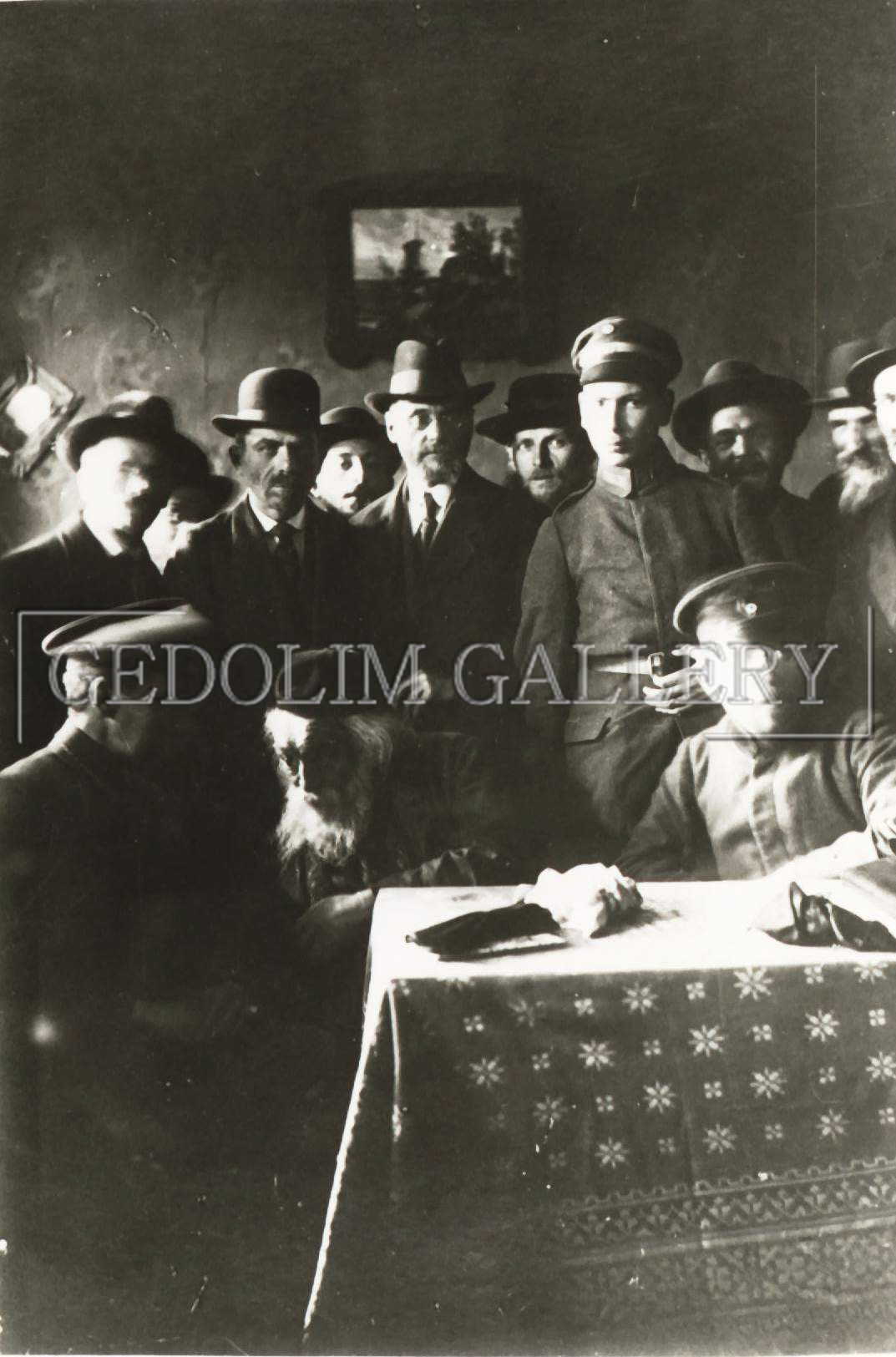 A group of men are gathered around a table in a black and white photo taken by gedolin gallery