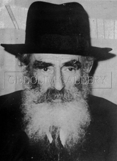 A black and white photo of a man with a beard wearing a hat