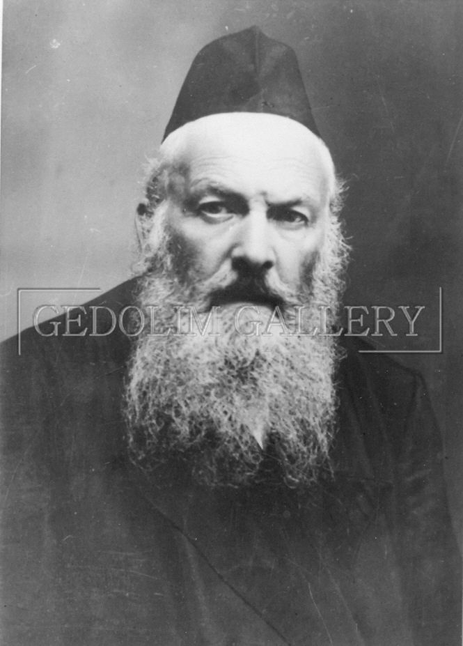 A black and white photo of a man with a beard and hat.