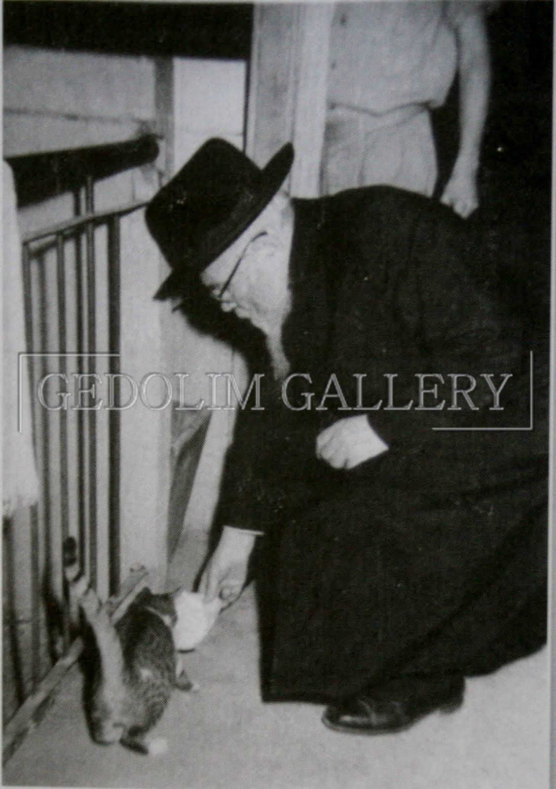 A black and white photo of a man petting a rabbit with the caption gedolin gallery