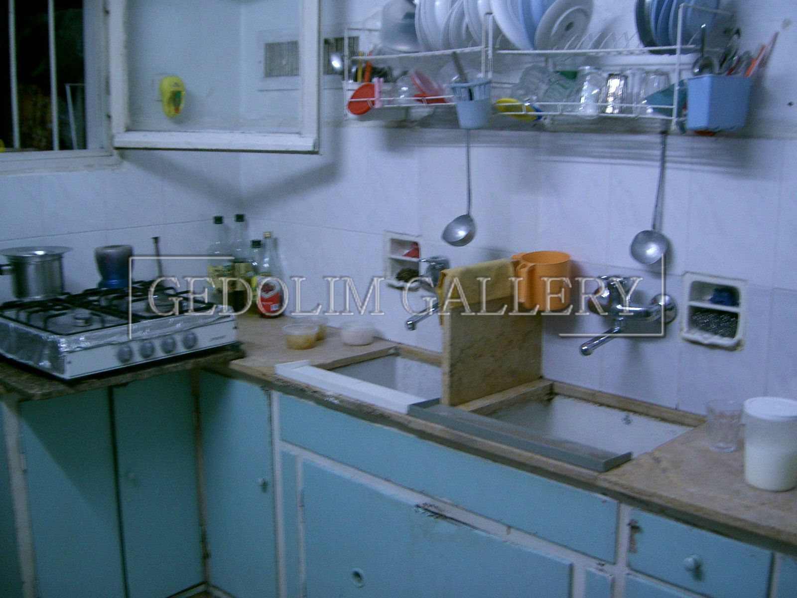 A kitchen with a sink and a stove with the word gallery on the bottom