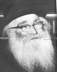 A black and white photo of a man with a beard and glasses.