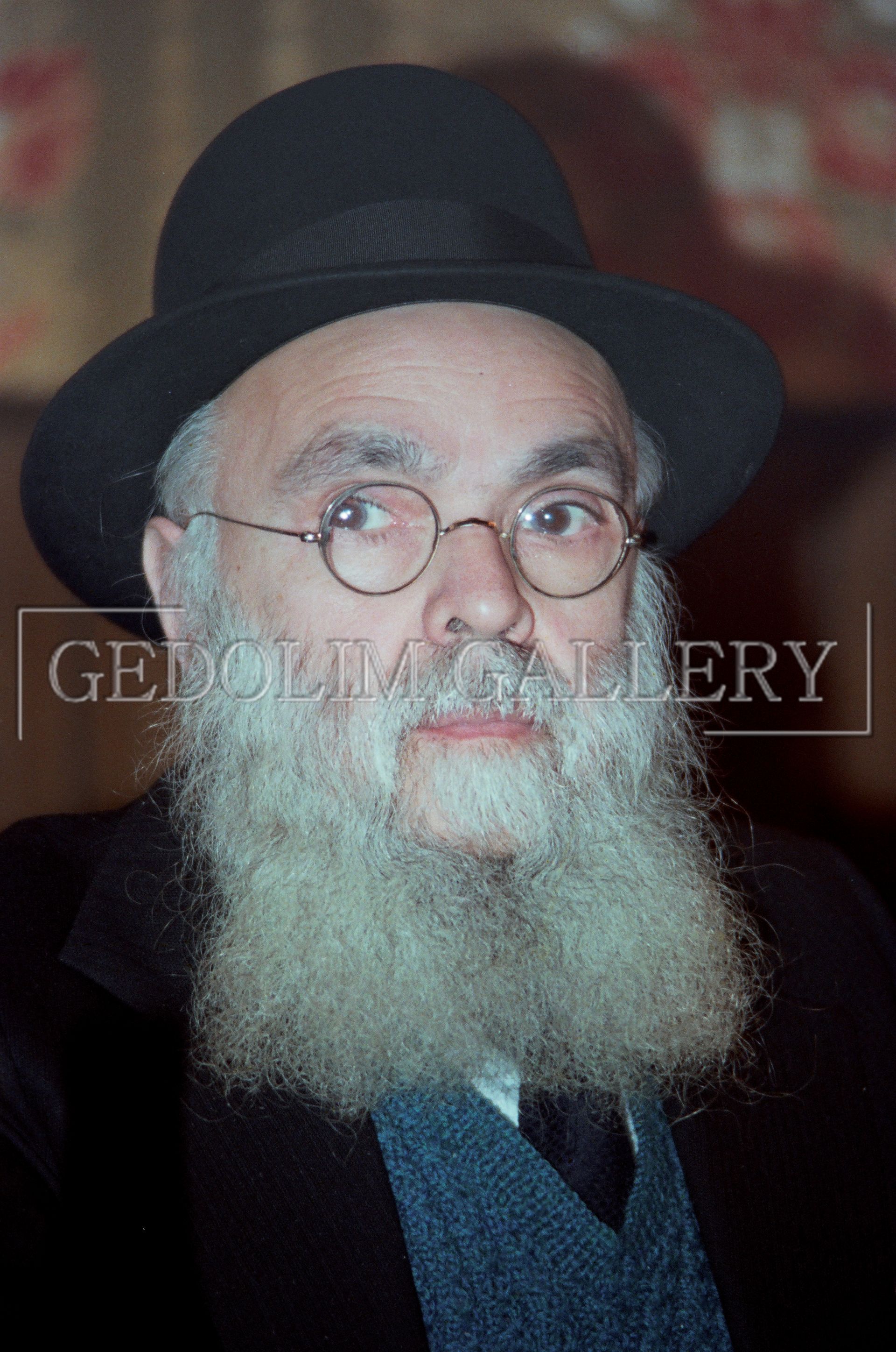 A man with a beard wearing a hat and glasses