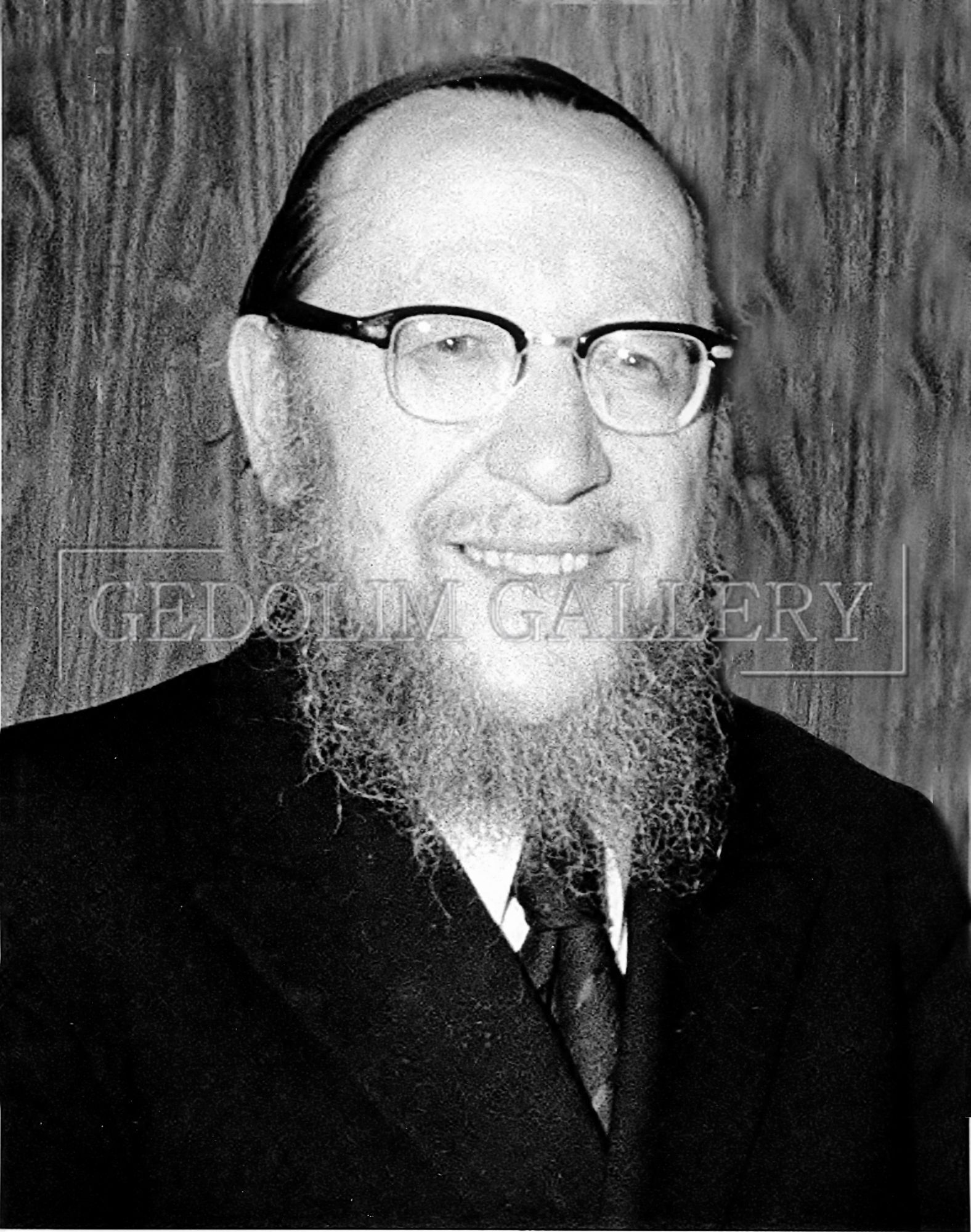 A black and white photo of a man with glasses and a beard
