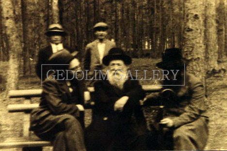 A group of people are sitting on a bench in the woods.
