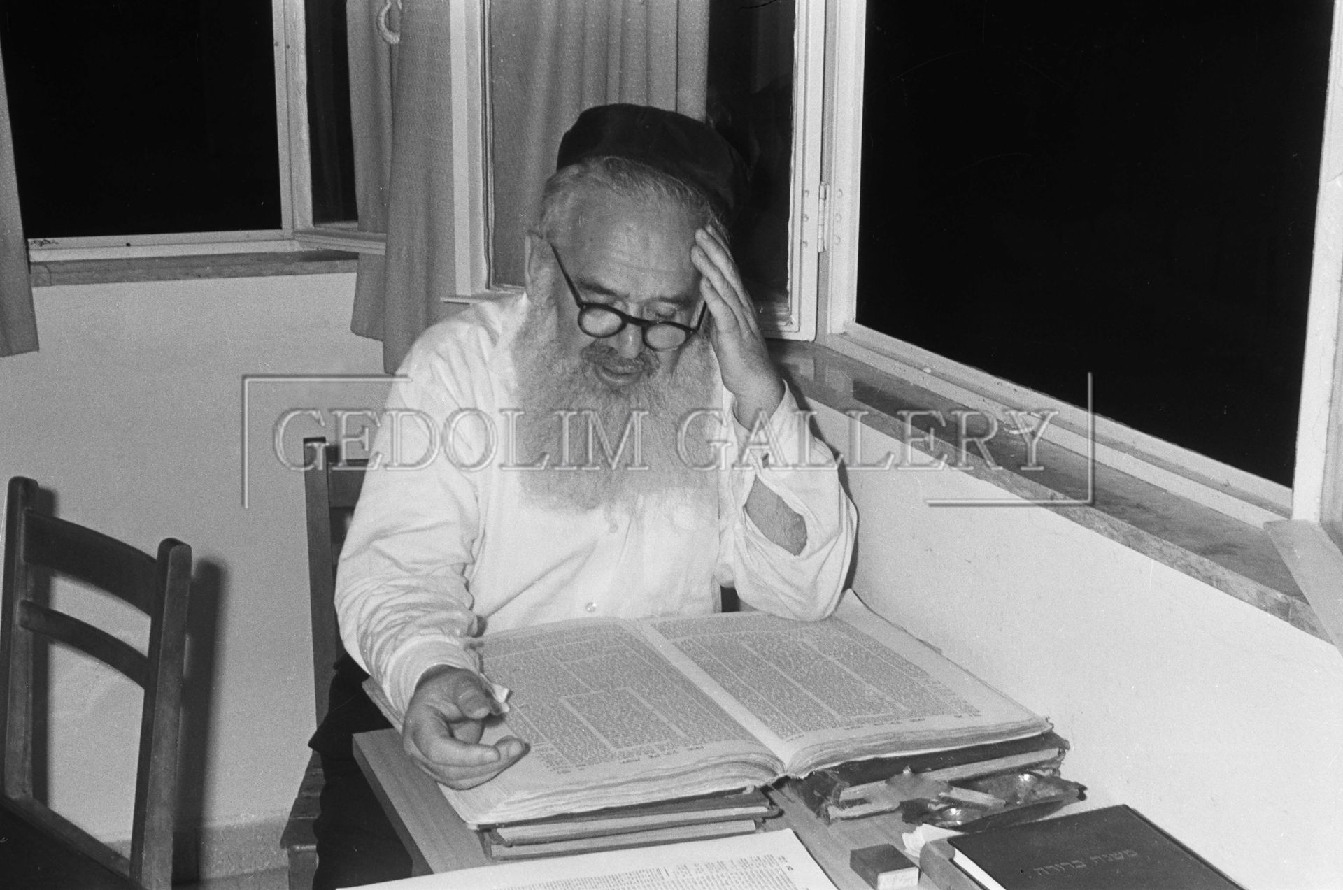A black and white photo of a man reading a book
