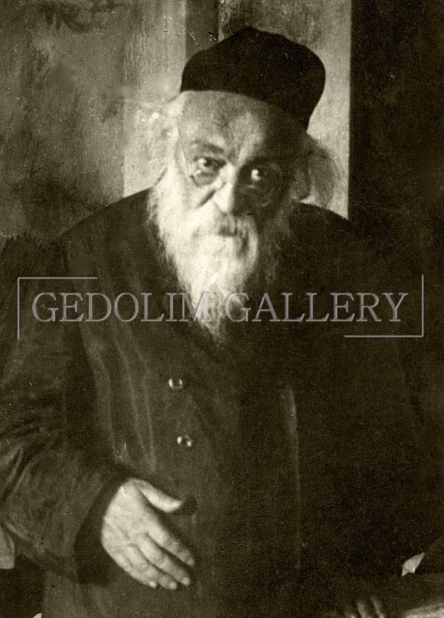 A black and white photo of a man with a beard and hat.