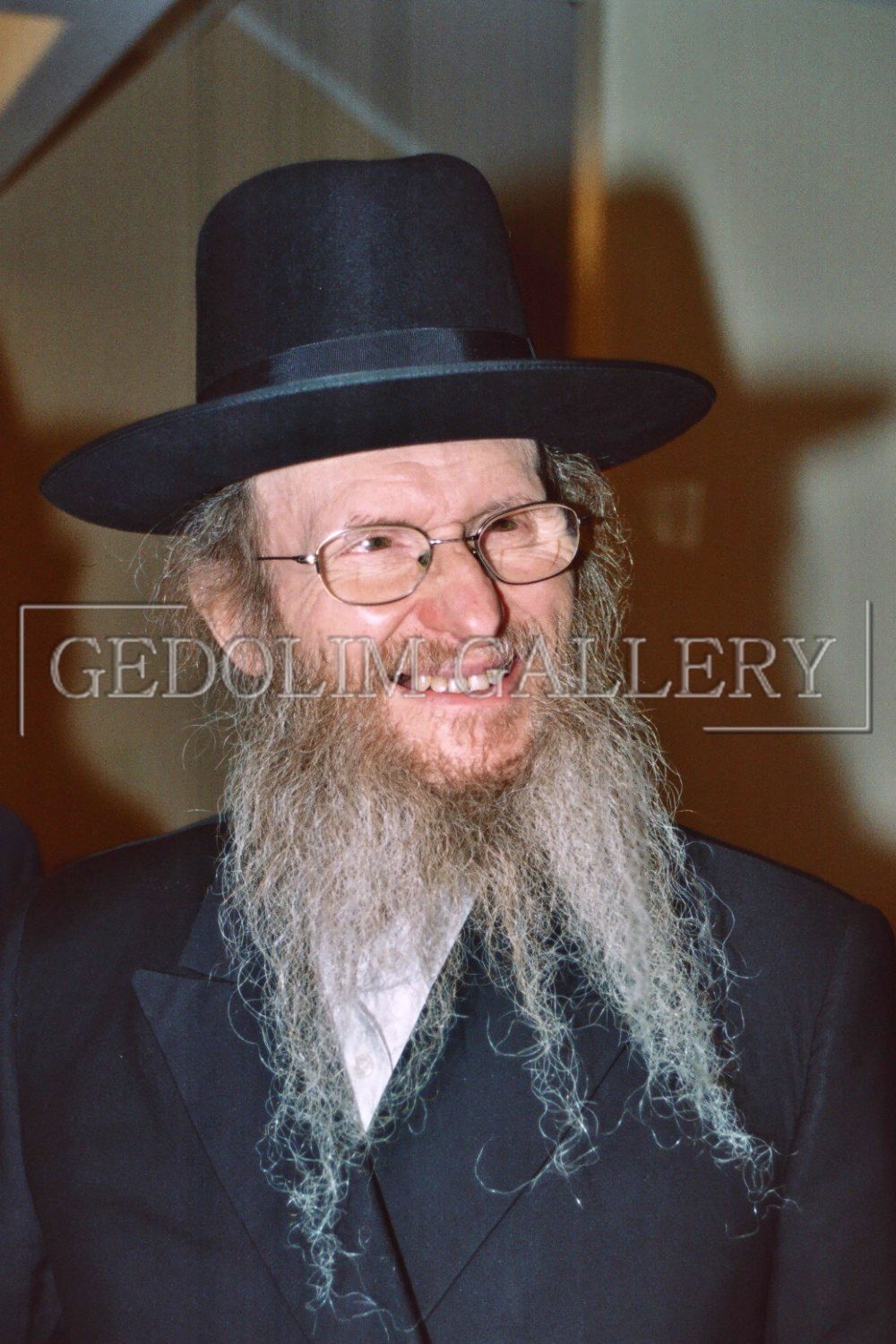 A man with a beard wearing a hat and glasses