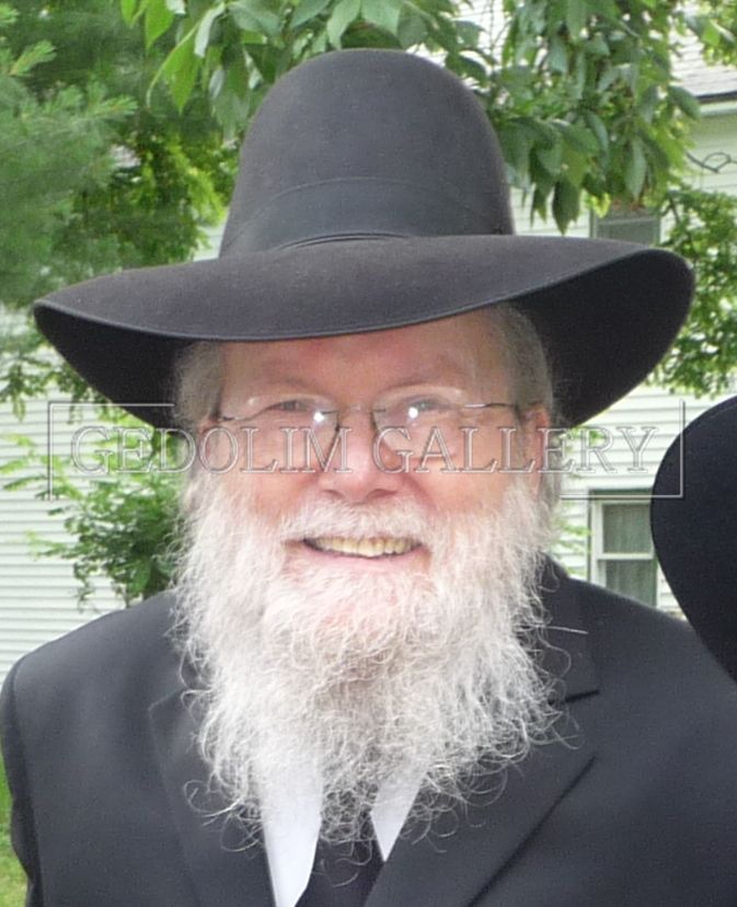 A man with a beard wearing a black hat and glasses