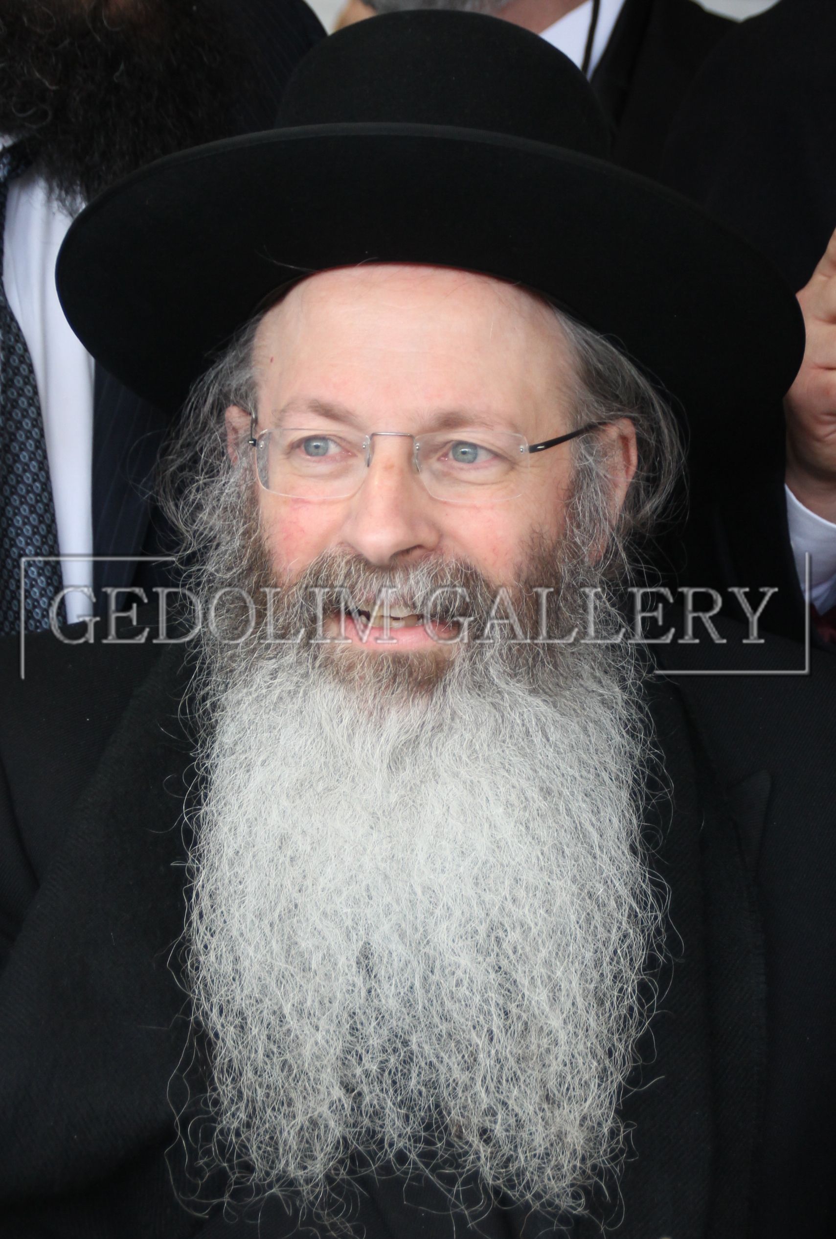 A man with a beard wearing a black hat and glasses