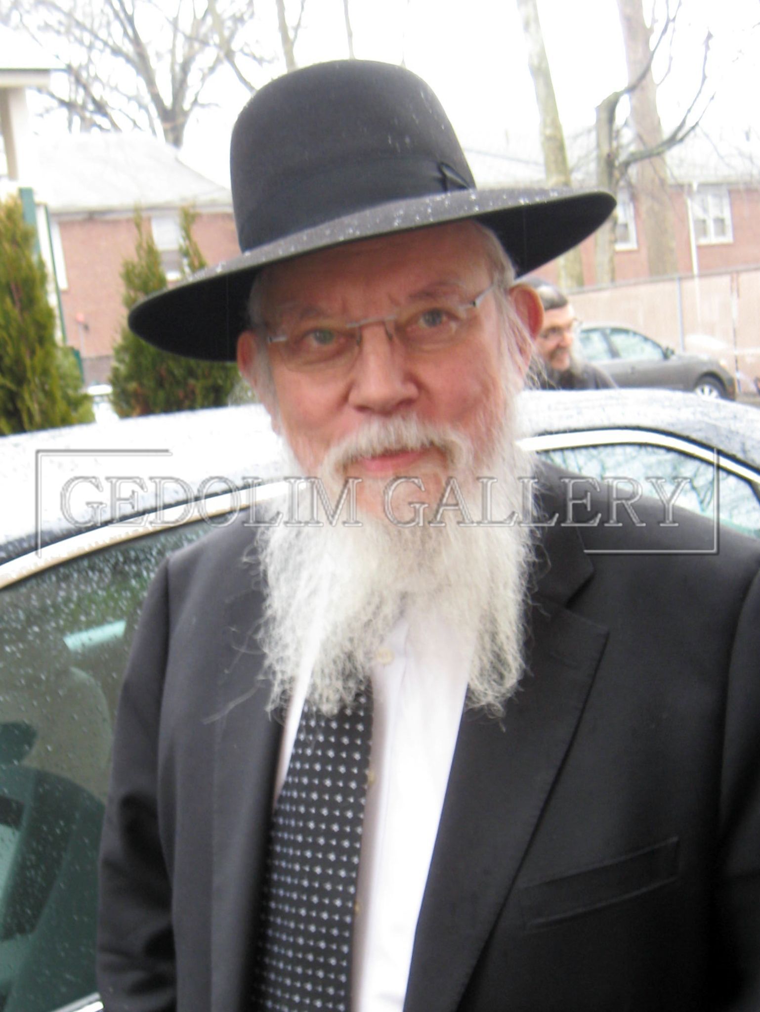 A man with a beard wearing a black hat and tie