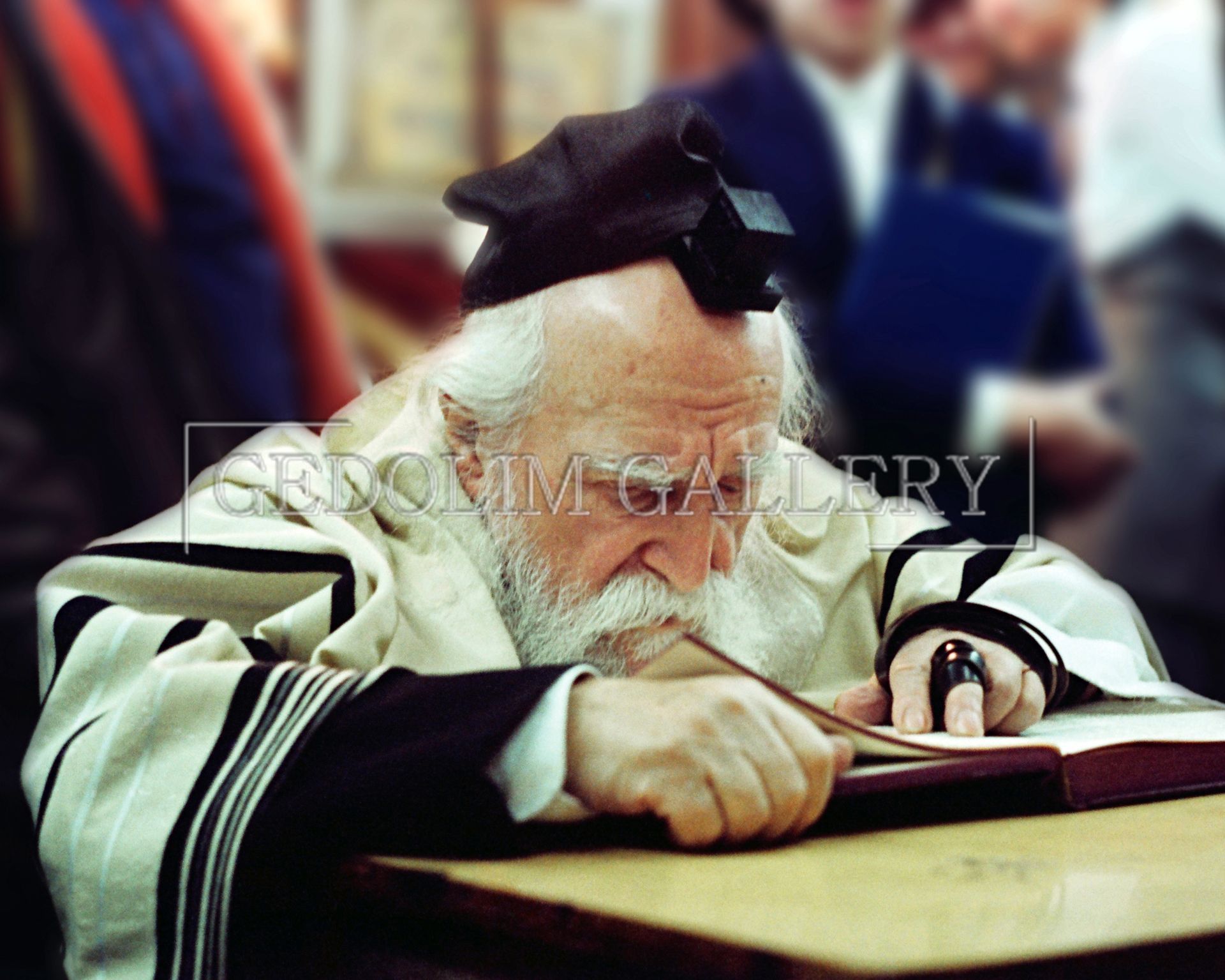 A man with a beard is sitting at a table reading a book