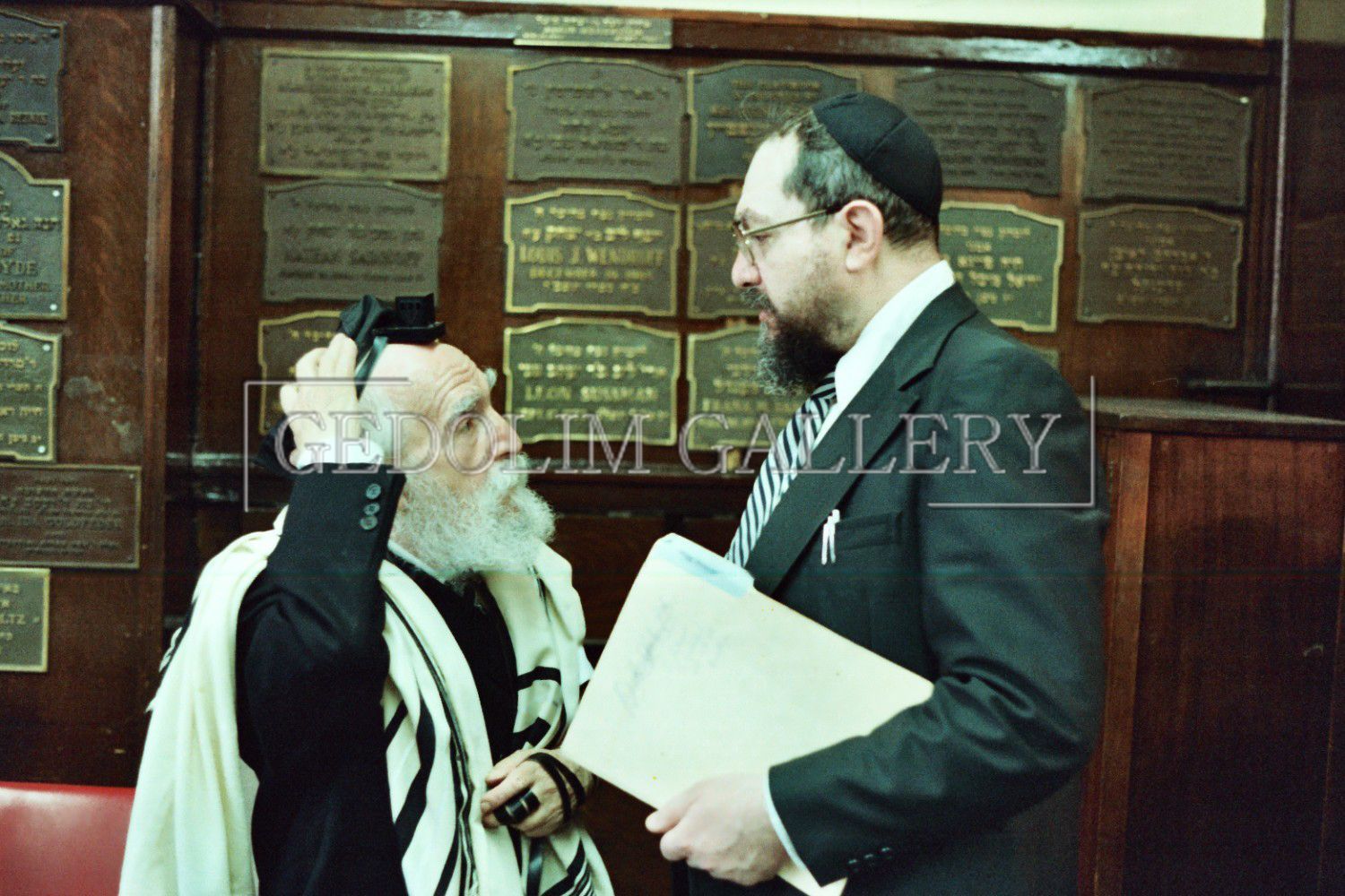 A man in a suit and tie is talking to another man