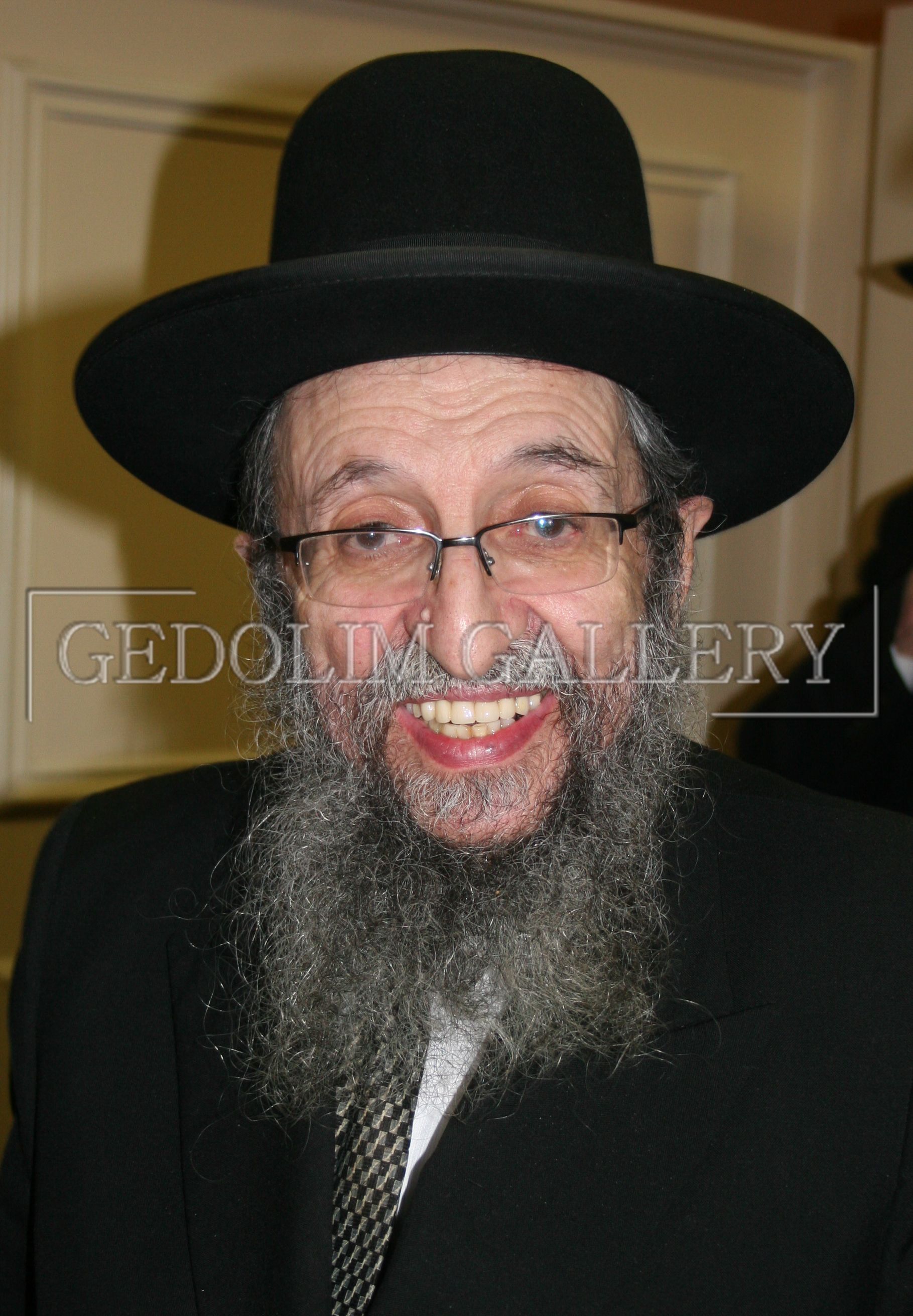 A man with a beard wearing a black hat and glasses
