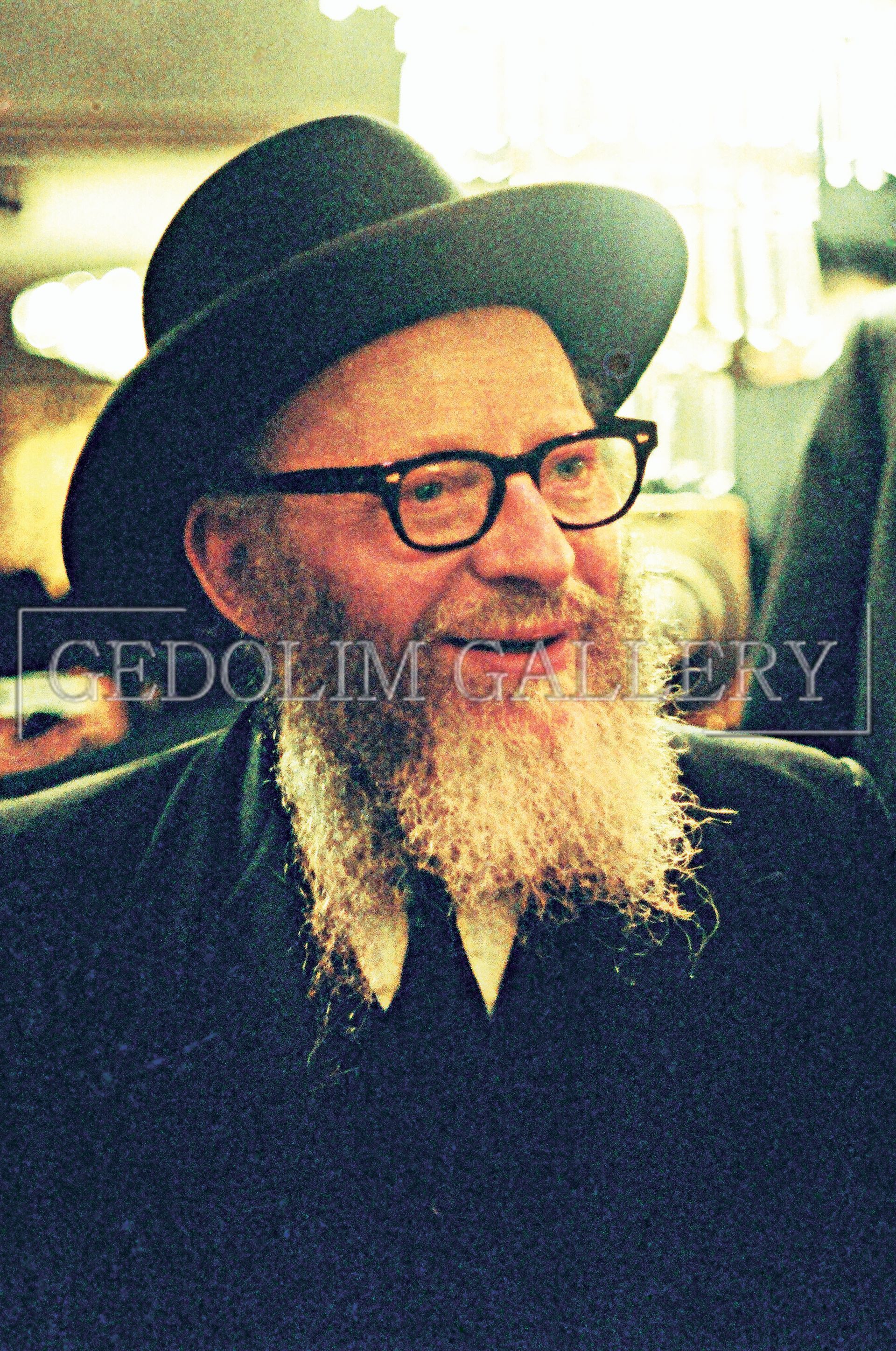 A man with a beard and glasses is wearing a hat.