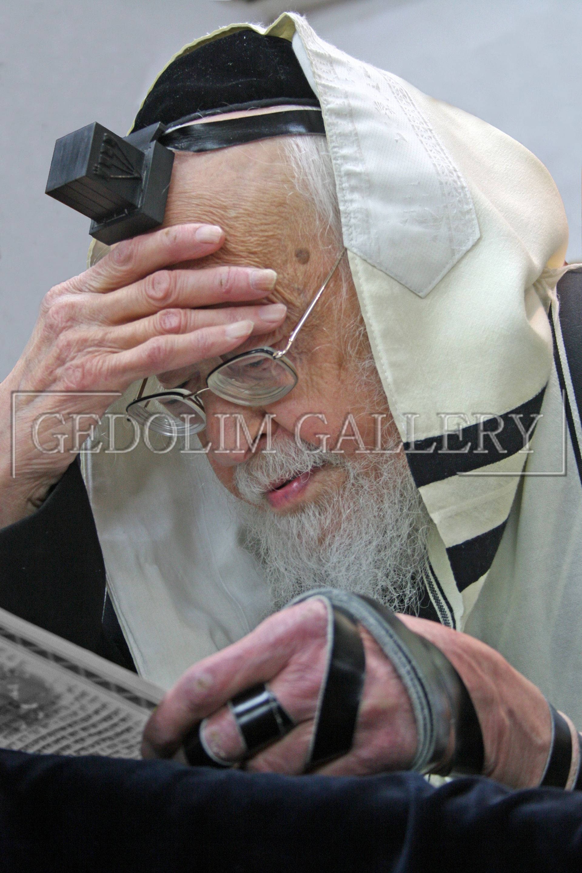 A man with a beard and glasses is reading a newspaper.