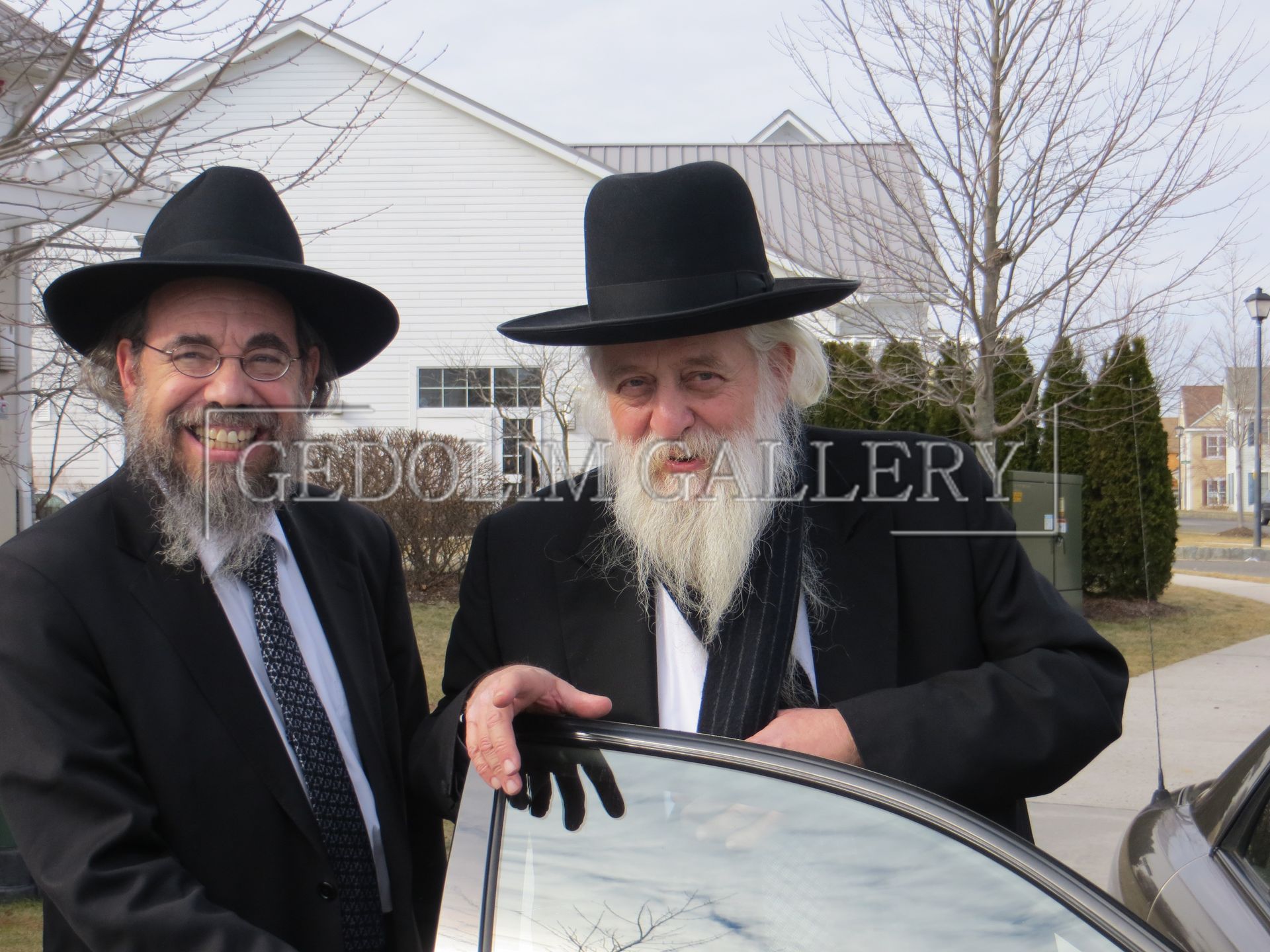 Two men standing next to a car with the word gallery on the bottom