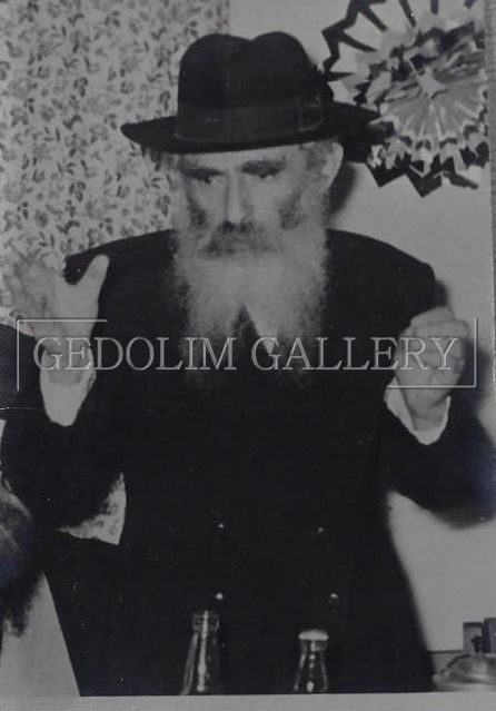 A black and white photo of a man with a beard wearing a hat