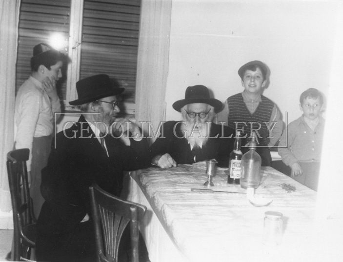 A black and white photo of a group of people sitting at a table.