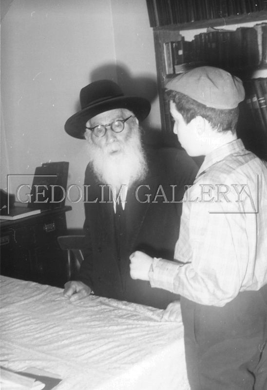 A man with a beard and glasses is talking to a young boy