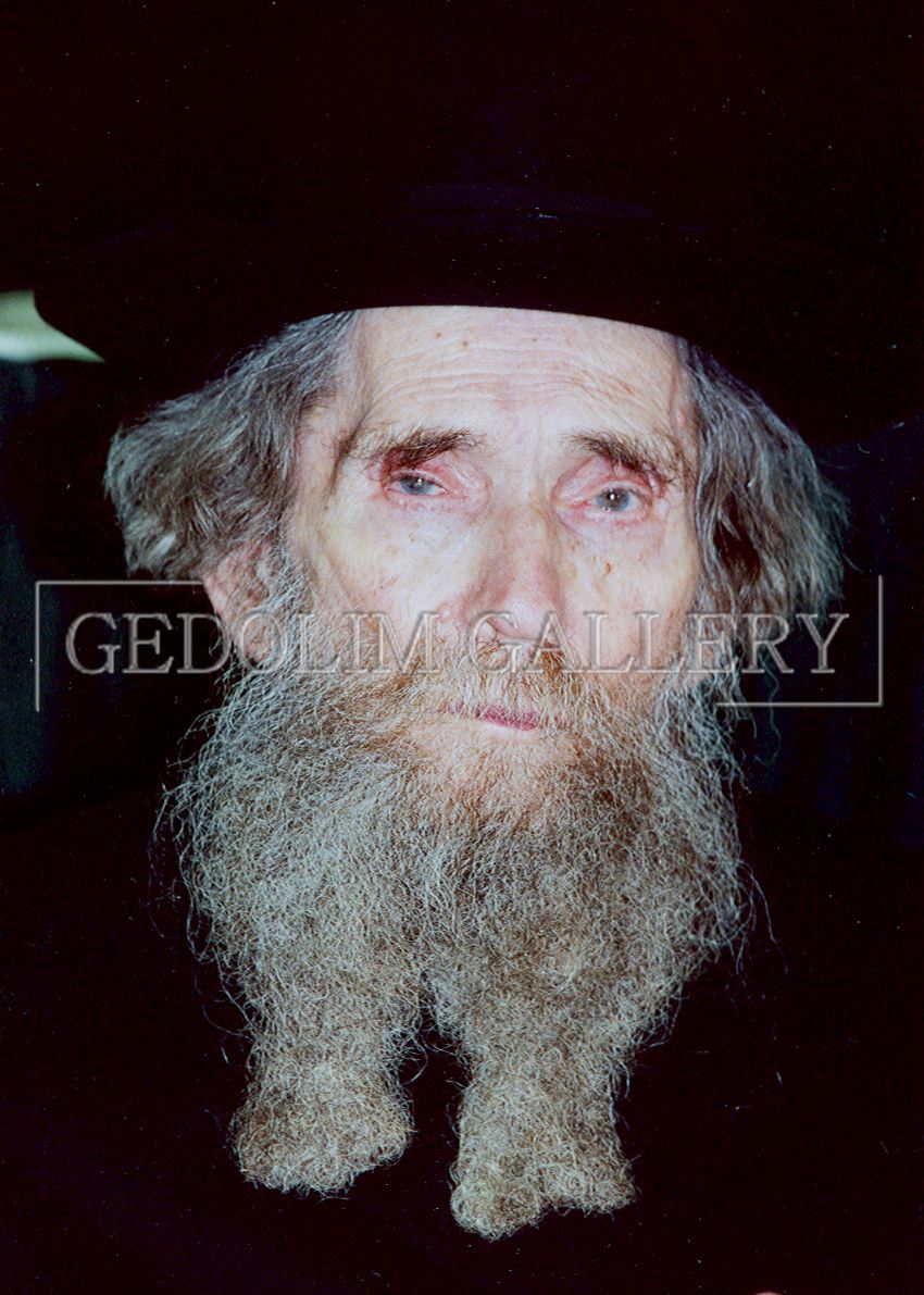 A man with a beard and a hat is wearing a black hat.