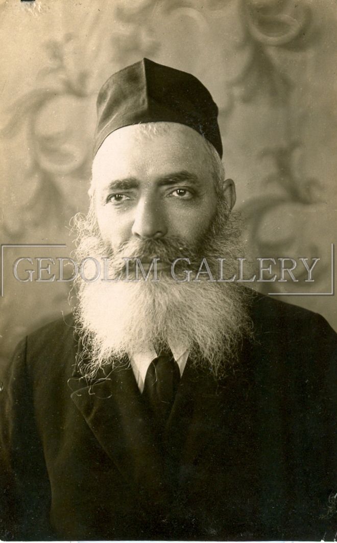 A black and white photo of a man with a beard and hat.