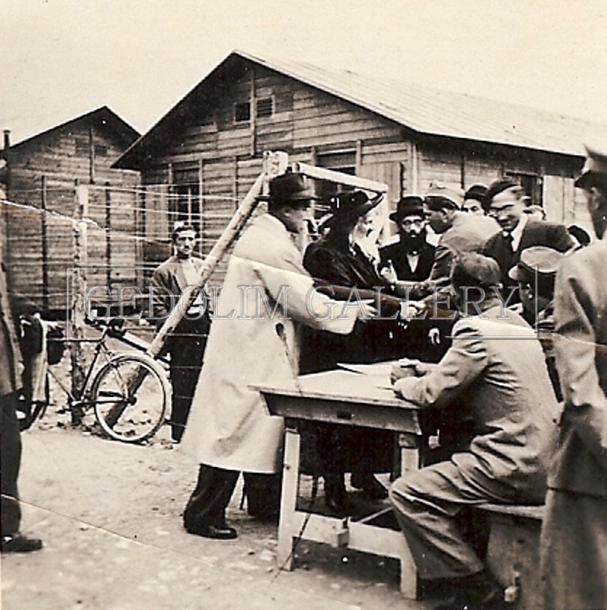 A black and white photo of a group of people standing around a table