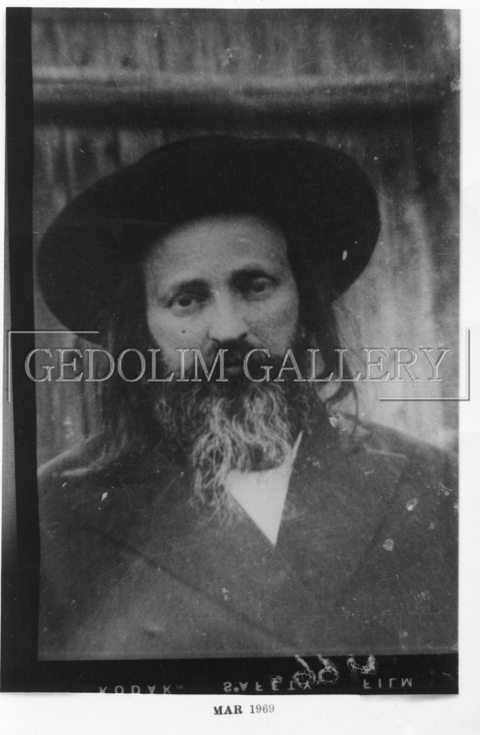 A black and white photo of a man with a beard wearing a hat.