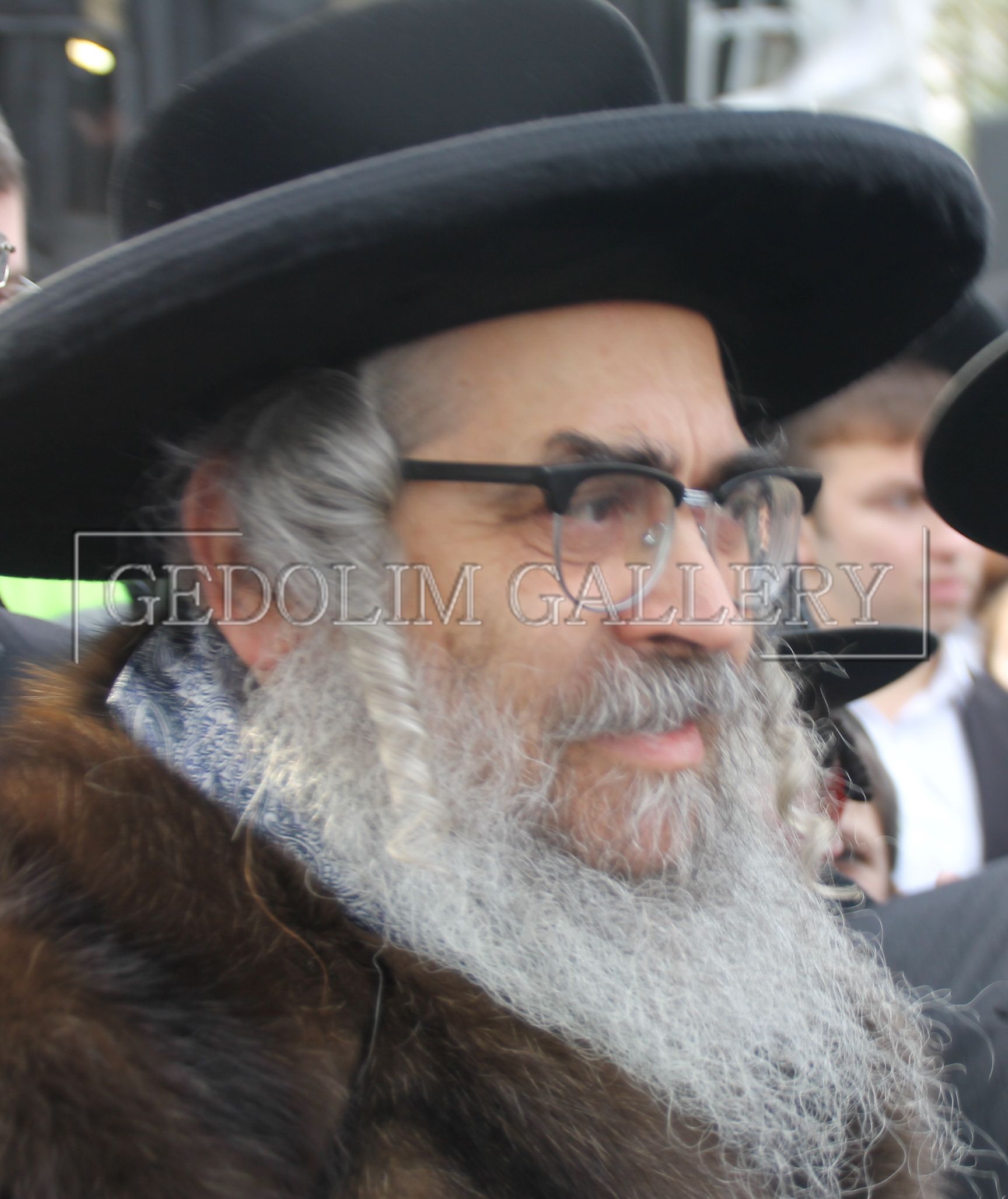 A man with a beard wearing a black hat and glasses