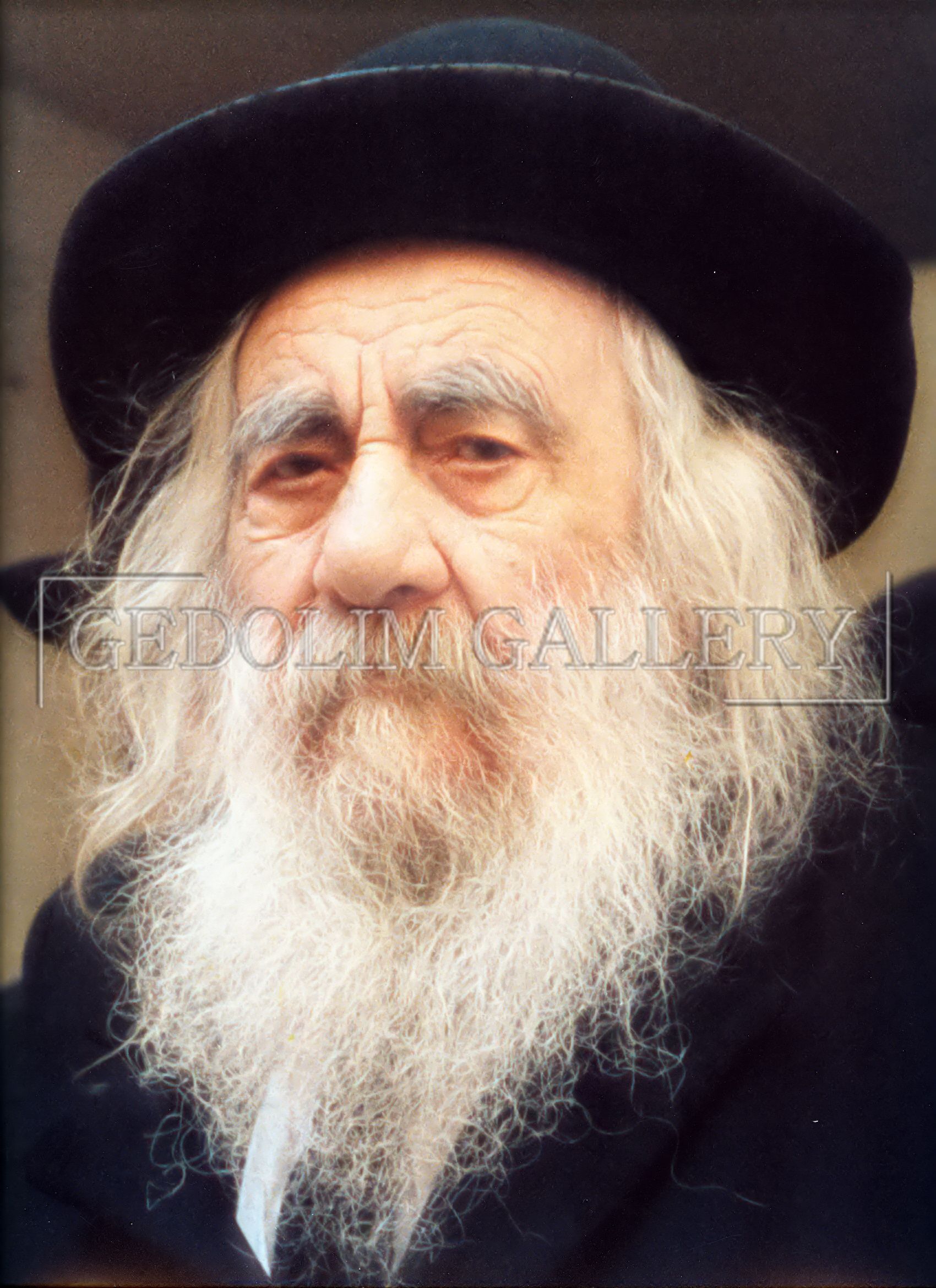 A man with long hair and a beard is wearing a black hat