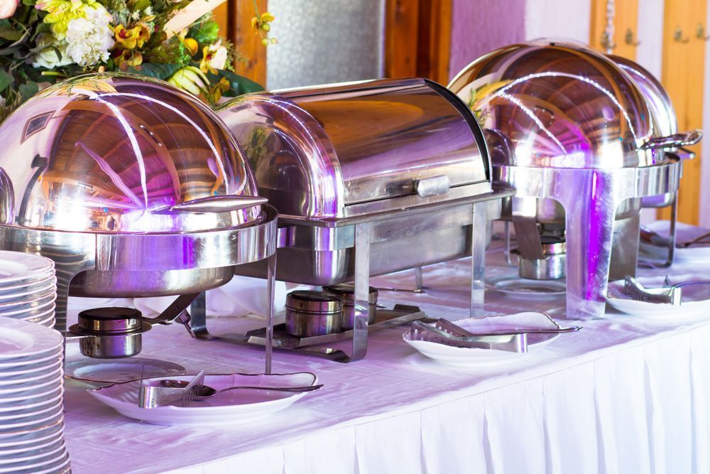 A Buffet Table With Plates, Utensils, And Stainless Steel Containers — Macleay Air In West Kempsey, NSW