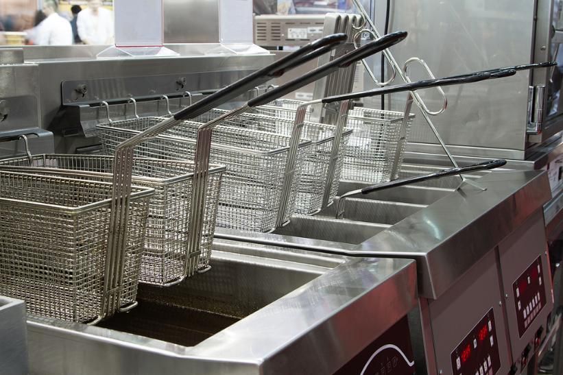 A Row Of Stainless Steel Fryers Are Lined Up In A Kitchen — Macleay Air In West Kempsey, NSW