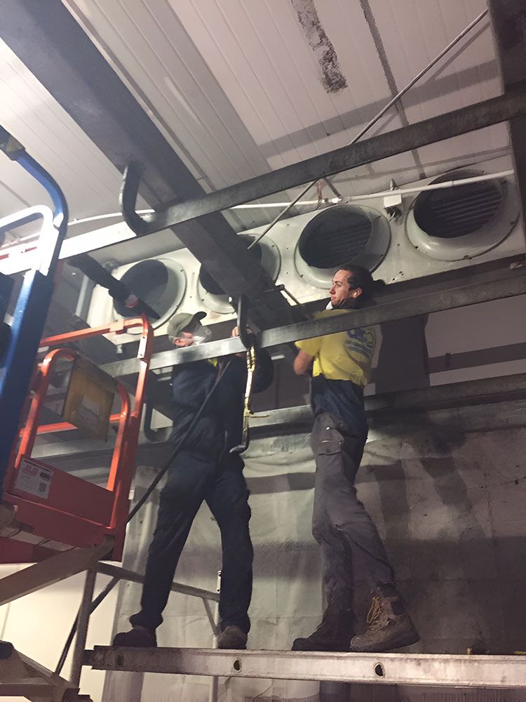 Two Men Are Working On The Ceiling Of A Building For Ventilation — Macleay Air In Nambucca Heads, NSW