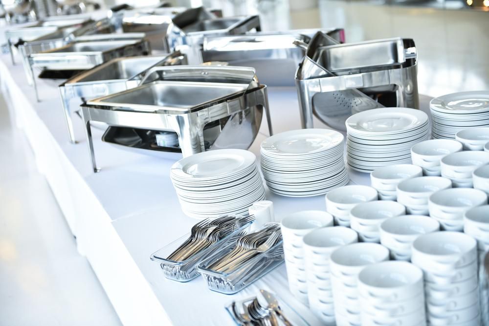 A Buffet Table Filled With Plates, Cups, Silverware And Utensils — Macleay Air In West Kempsey, NSW