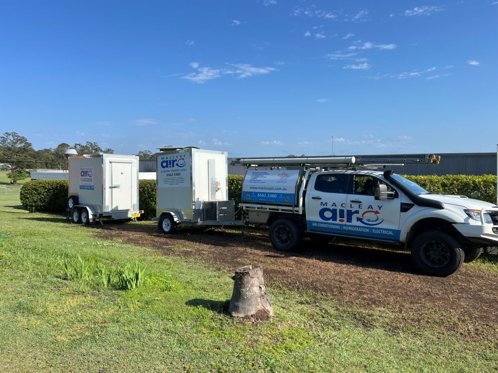 A Truck And Trailer Are Parked In A Grassy Field — Macleay Air In Macksville, NSW