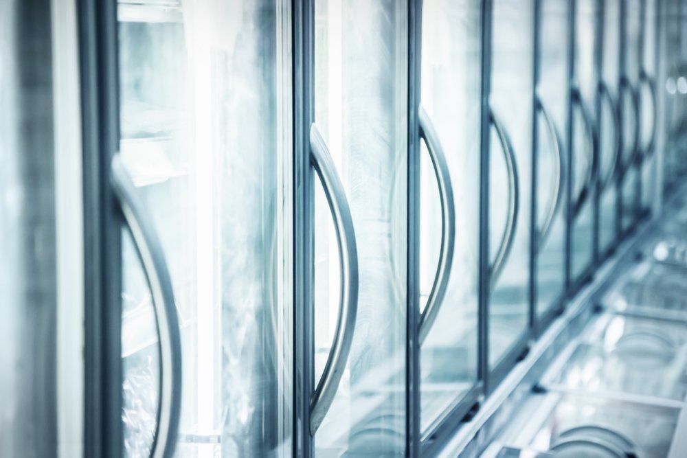 A Row Of Refrigerators With Glass Doors And Handles In A Store — Macleay Air In West Kempsey, NSW