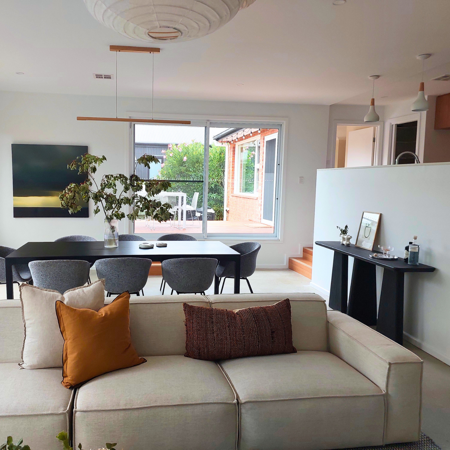 Open-Concept Living Space With Dining Area, Sofa, and a View of a Backyard Through a Sliding Door — Elimar Construction in Goulburn, NSW