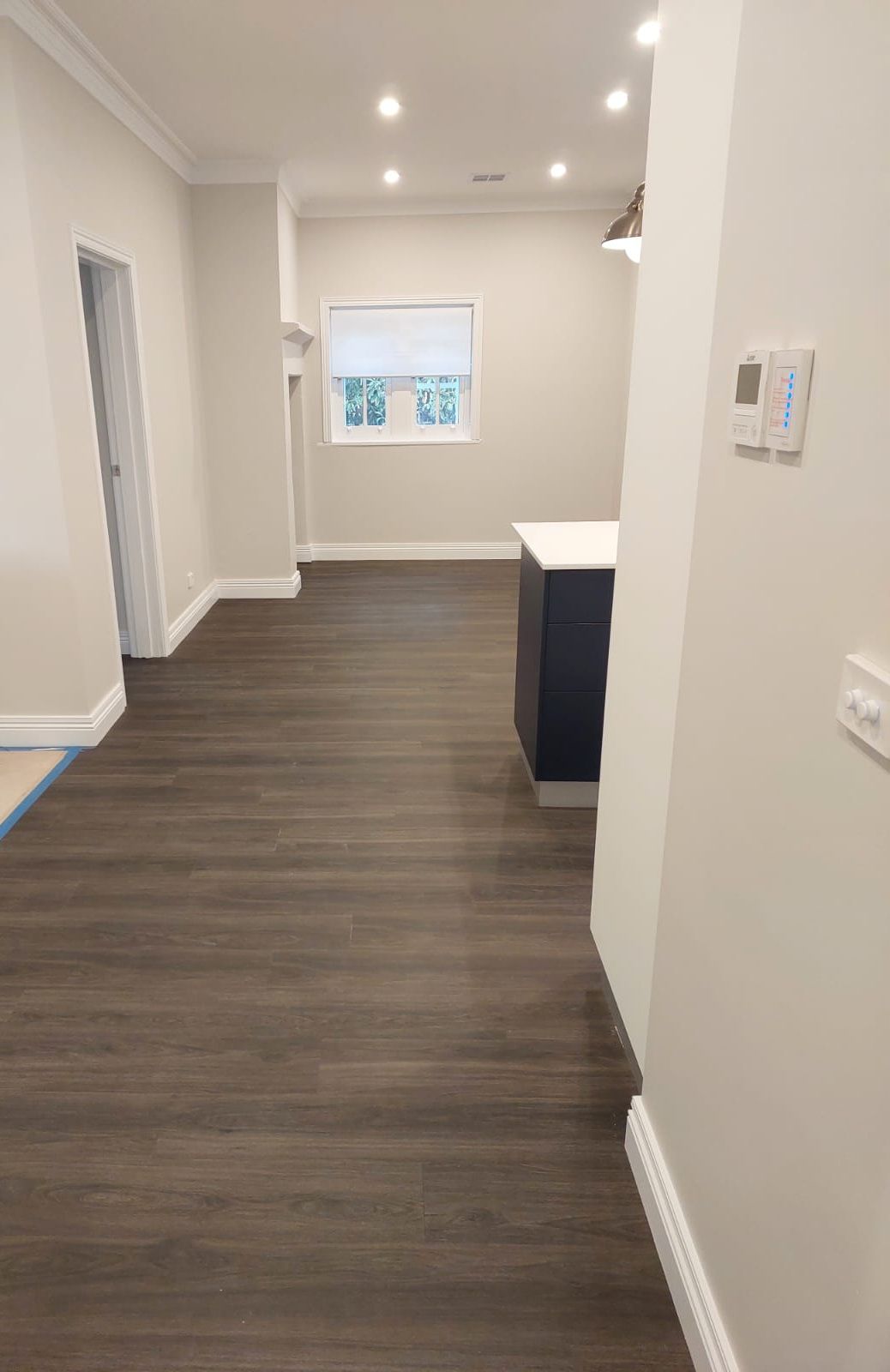 Interior View of a Room With Dark Wood Flooring, Light Walls, and a Kitchen Island — Elimar Construction in Goulburn, NSW