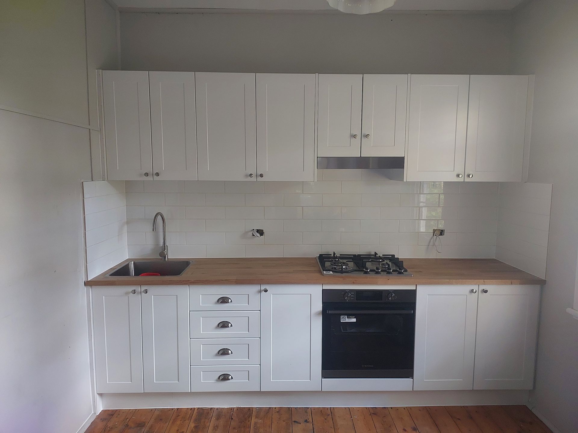 A Kitchen With White Cabinets and Wooden Counter Tops — Elimar Construction in Goulburn, NSW