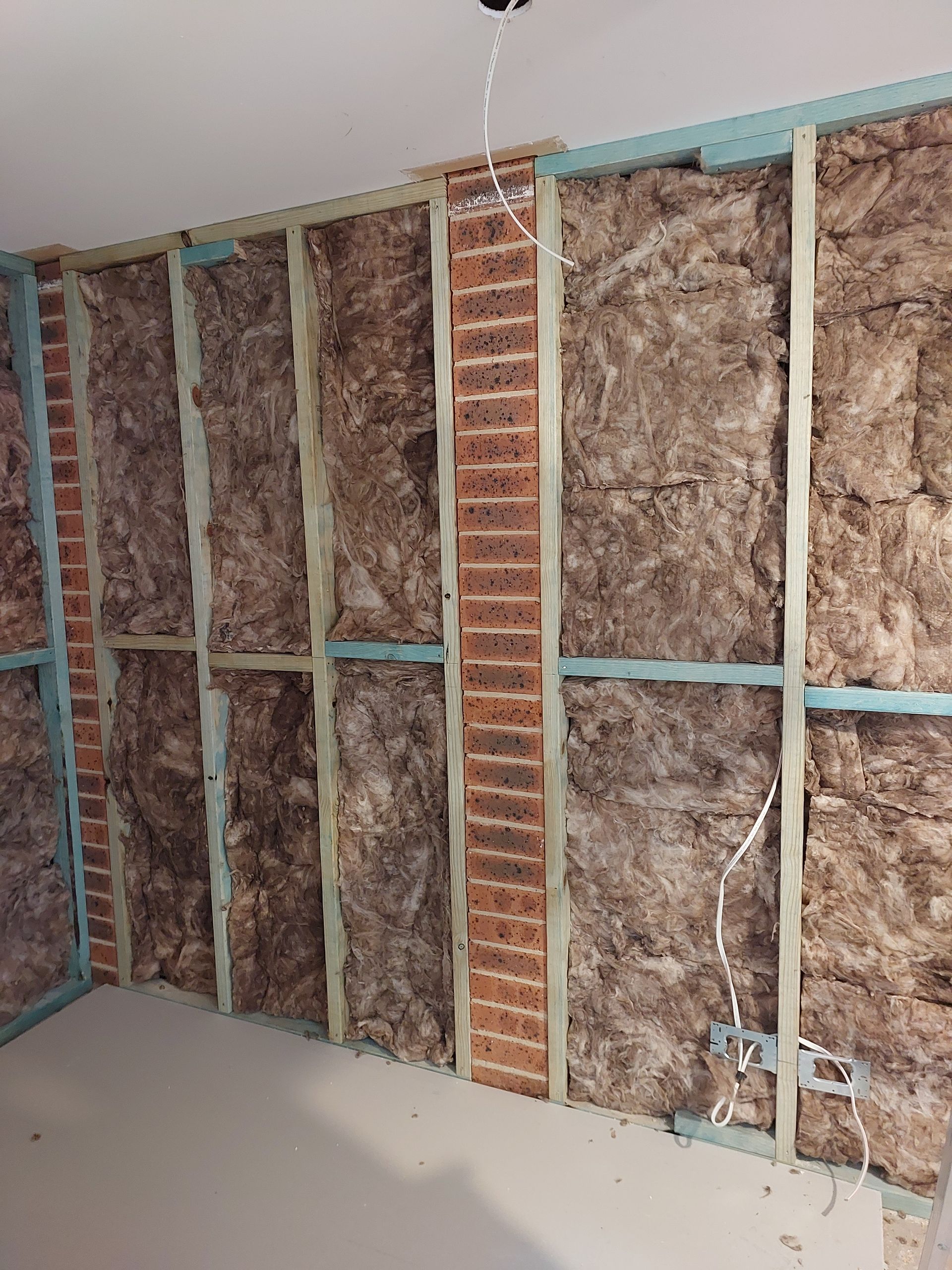 Interior Wall Under Construction With Insulation Between Wooden Studs, Brick Accents — Elimar Construction in Goulburn, NSW