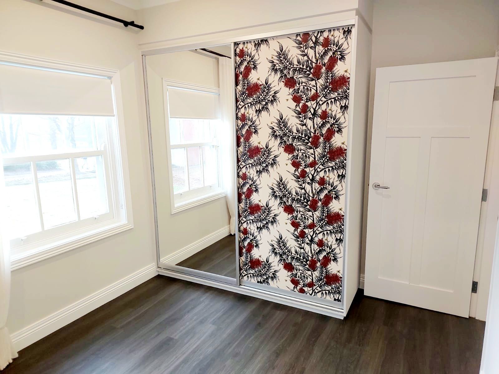 Bedroom With Mirrored Closet Doors and Floral Design, Two Windows, and Dark Wood Flooring — Elimar Construction in Goulburn, NSW