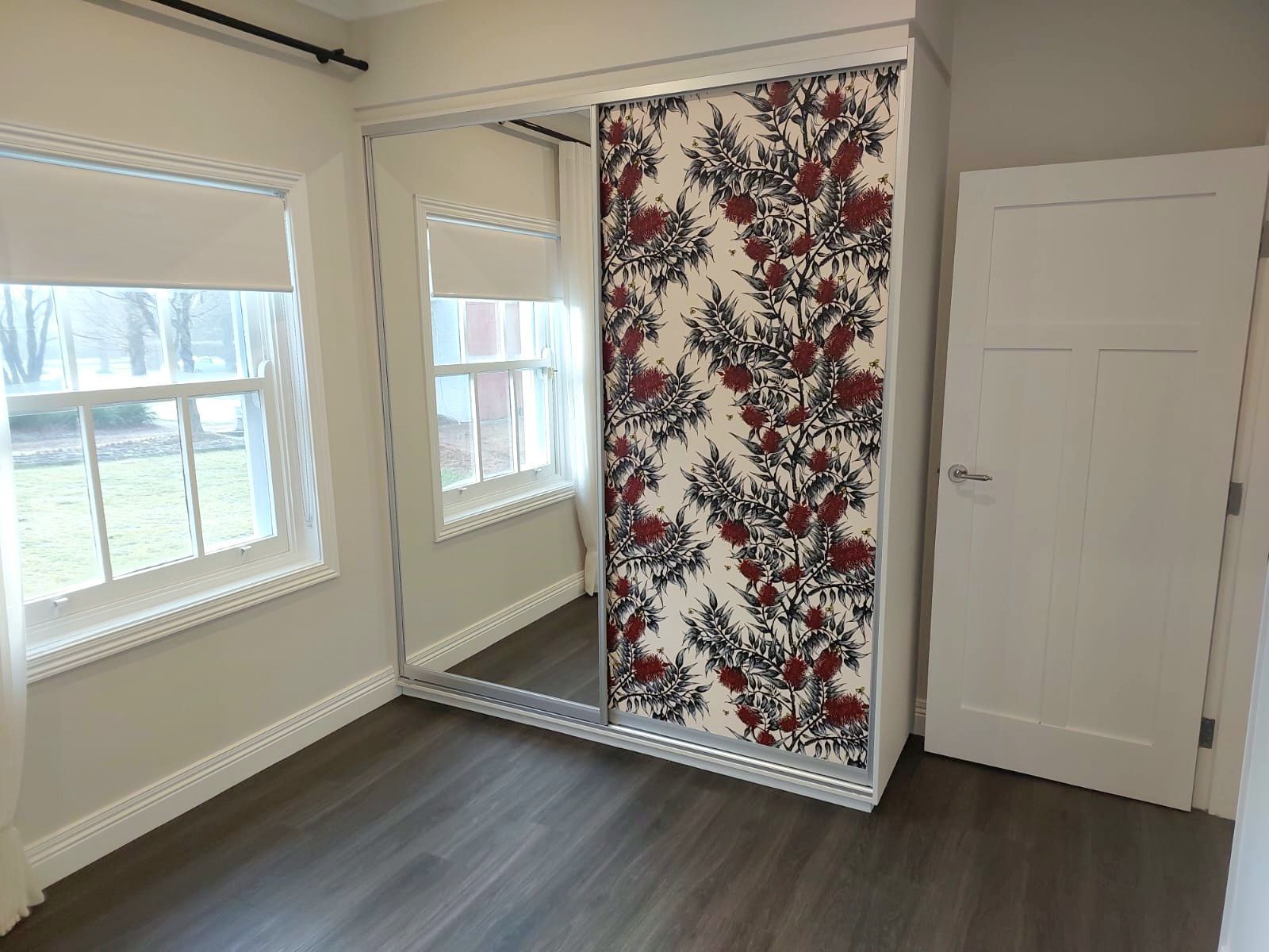 Bedroom With Mirrored Sliding Closet Doors and Floral Patterned Panel — Elimar Construction in Goulburn, NSW