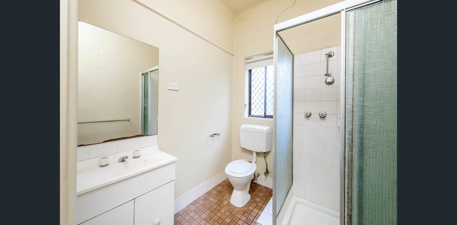 Bathroom With Shower, Toilet, and Vanity. Off-white Walls, Tiled Floor, and a Window in the Center — Elimar Construction in Goulburn, NSW