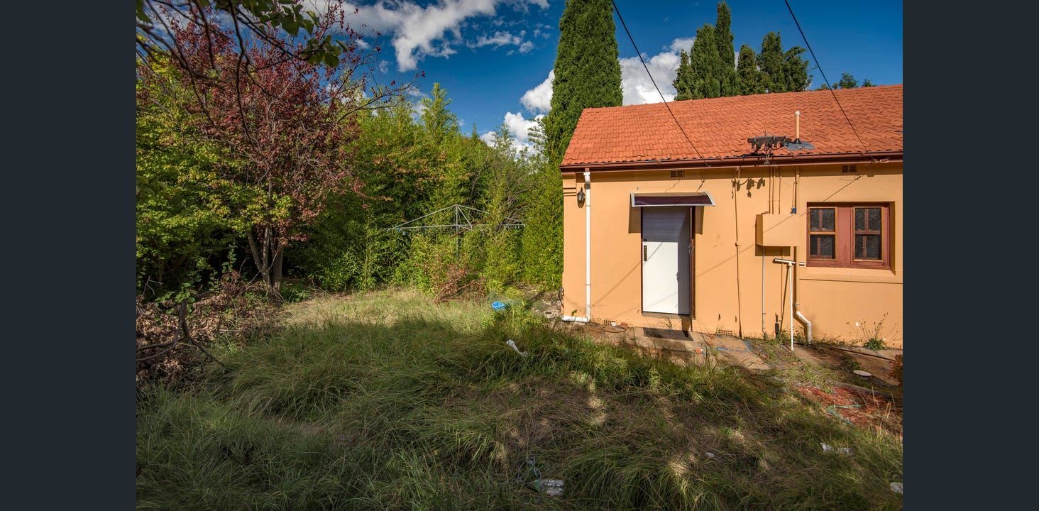 Small, Orange Building With Red Tile Roof, Surrounded by Trees and Overgrown Grass, Under a Blue Sky — Elimar Construction in Goulburn, NSW