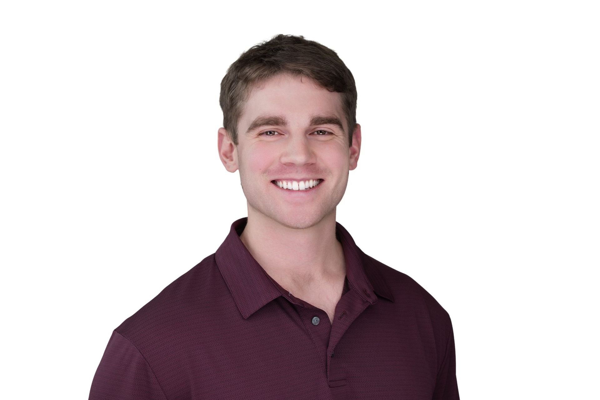 Man smiling, wearing a dark red collared shirt, against a white background.