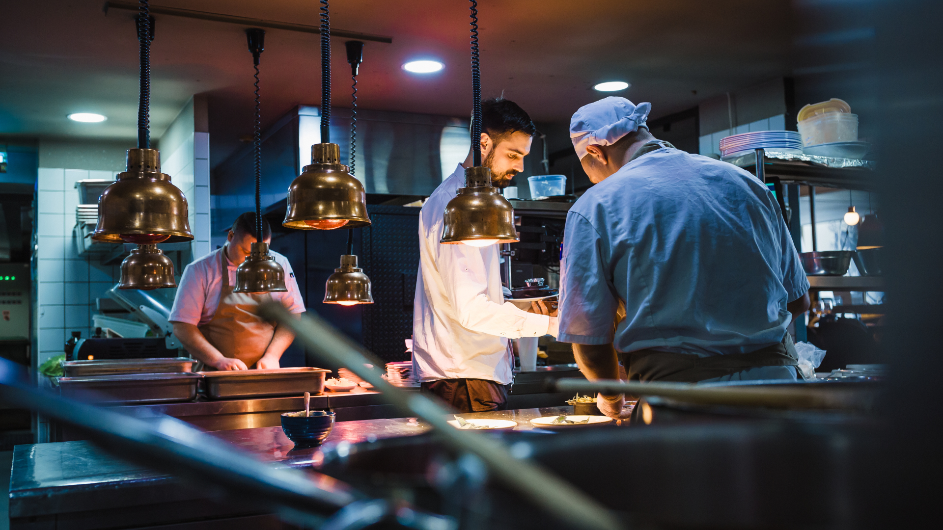 A group of chefs are working in a kitchen preparing food.